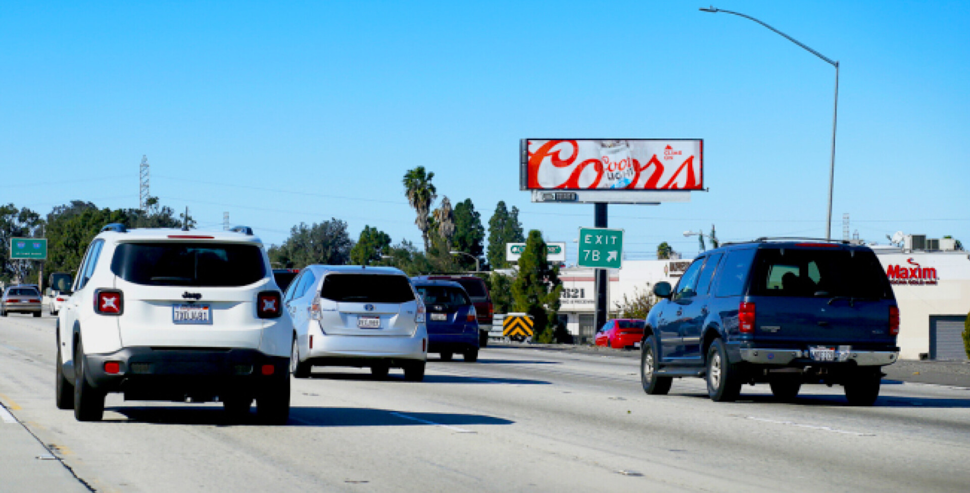 Highway traffic with roadside billboard (Coors sign)