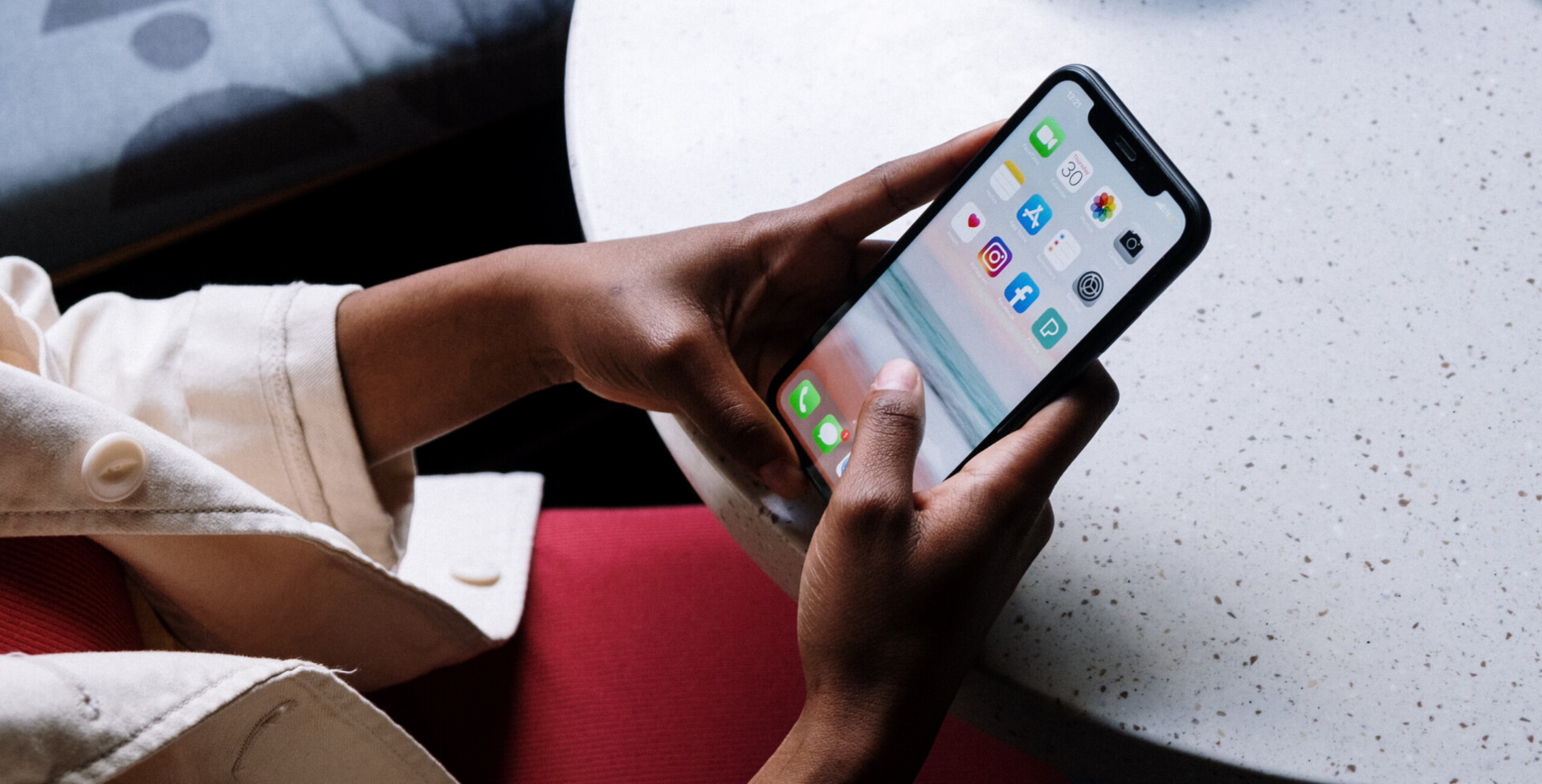 Hands holding a smartphone above a desk