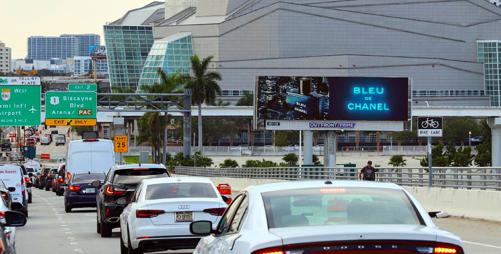 Convention center digital screens with cars in foreground