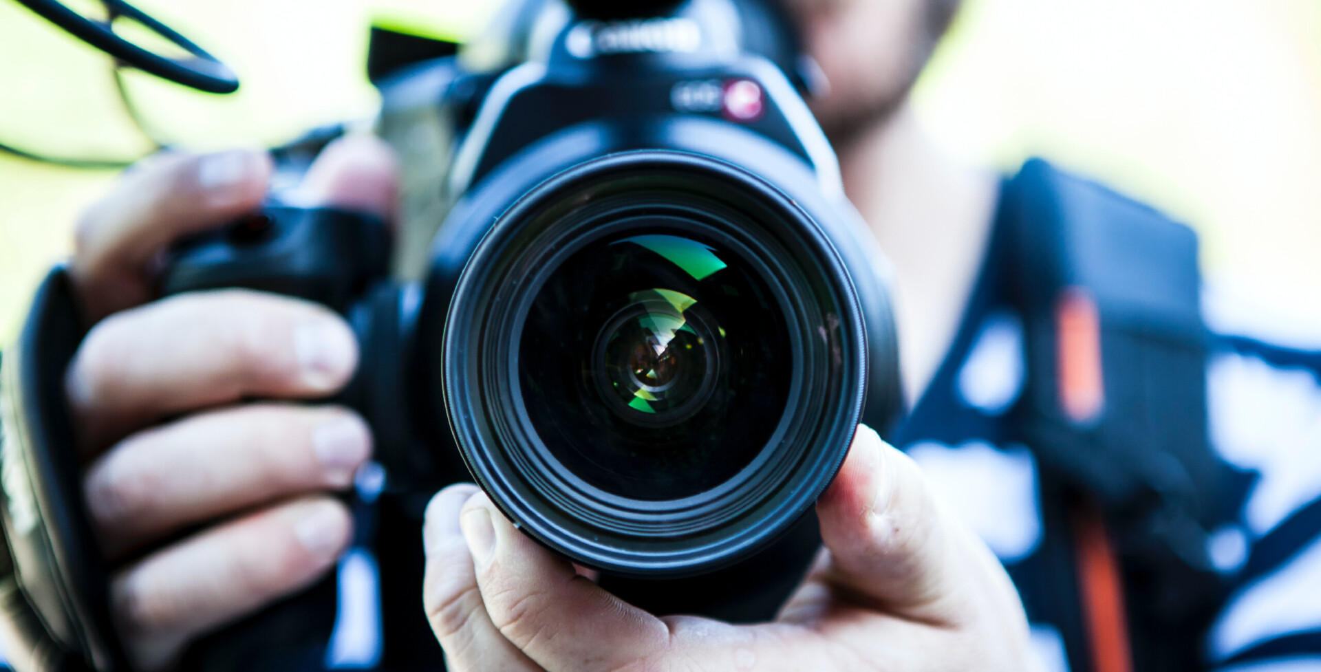 Close-up of photographer holding camera lens
