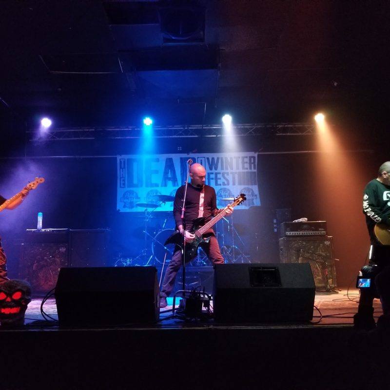 Live band performing on stage with blue lights