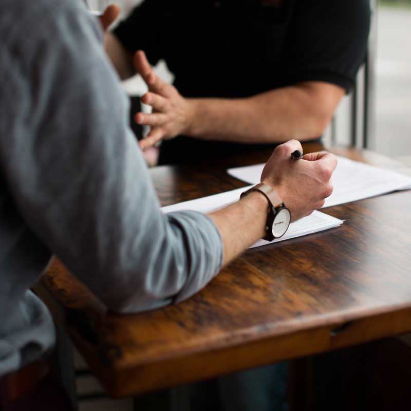 Hands writing notes during meeting at table