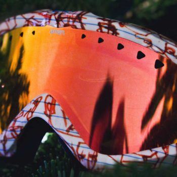Ski goggles close-up with mountain reflection
